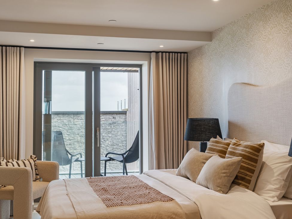 A bedroom with a bed and chairs at tbc in St. Ives