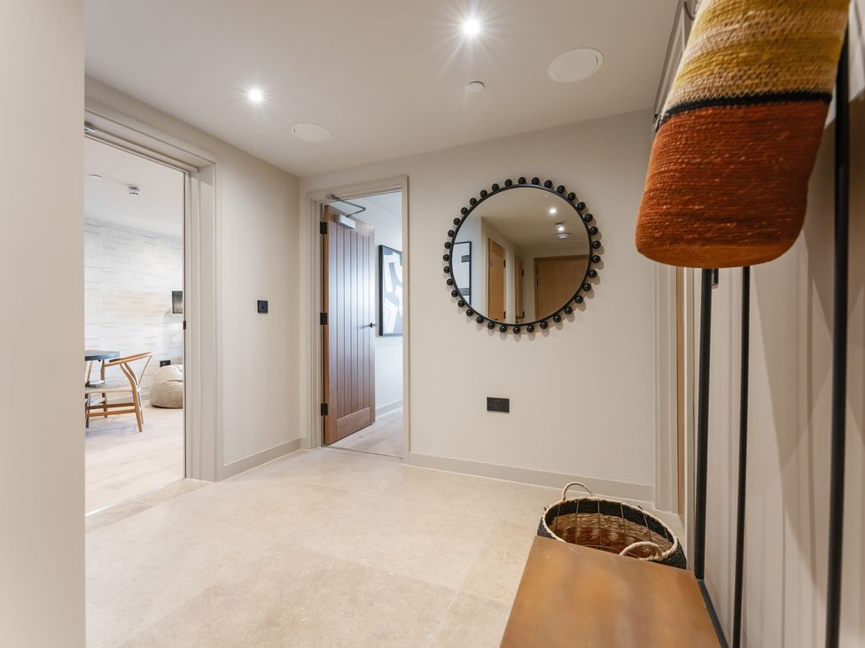 A hallway with a mirror and door at tbc in St. Ives