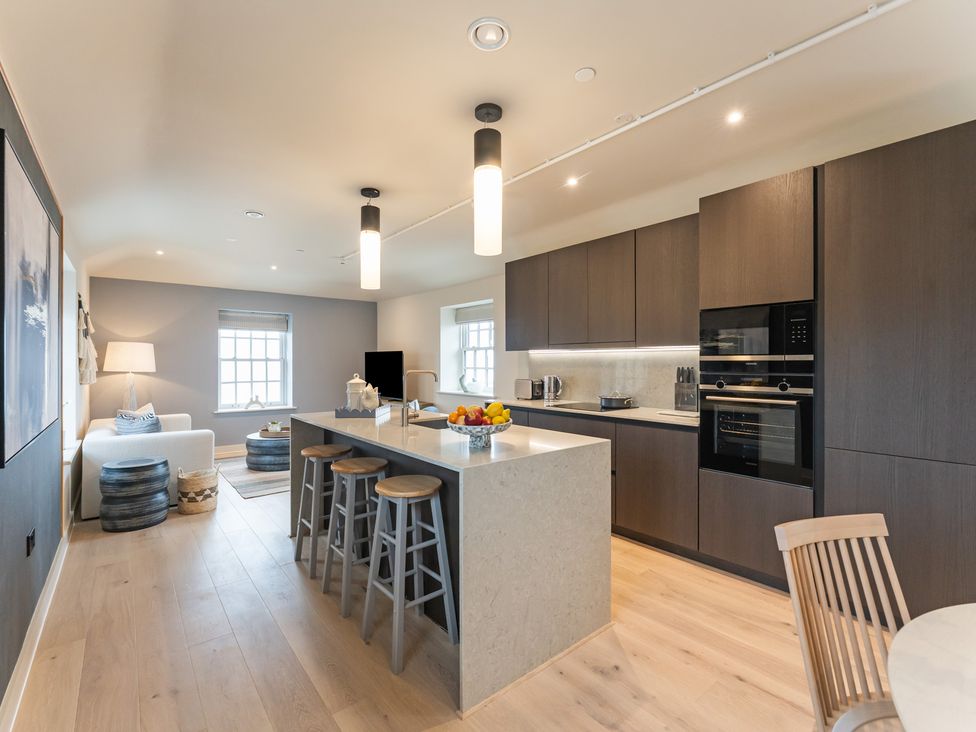 A kitchen with an island and stools at tbc in St. Ives