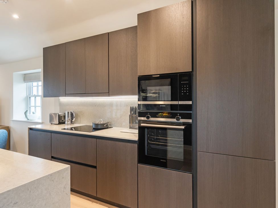 A kitchen with cabinets, a hob, and appliances at tbc in St. Ives