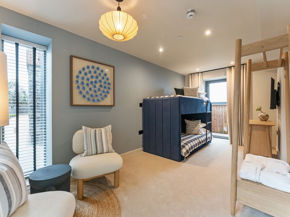 A bedroom with a bunk bed and seating area at tbc in St. Ives