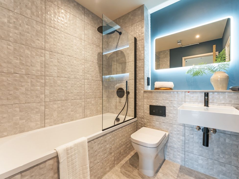 A bathroom with a bathtub, shower, toilet, and sink at tbc in St. Ives