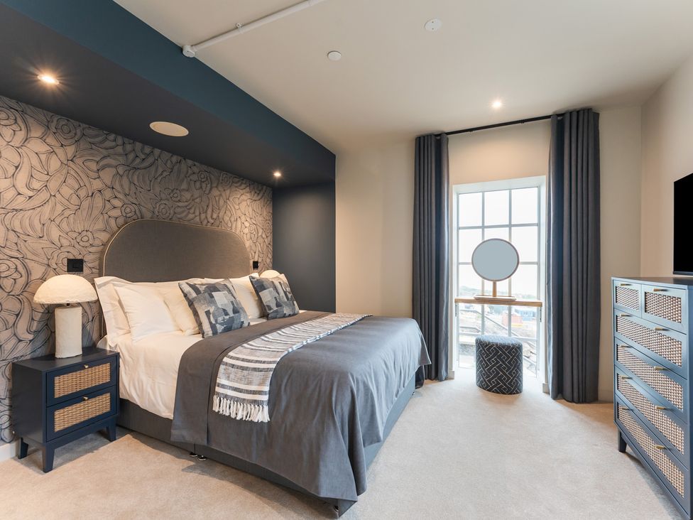 A bedroom with a bed and dresser at tbc in St. Ives