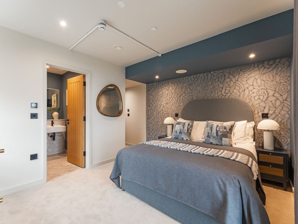 A bedroom with a bed and a door leading to a bathroom at tbc St. Ives