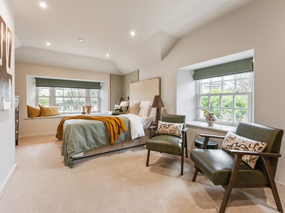 A bedroom with a bed and chairs at tbc in St. Ives