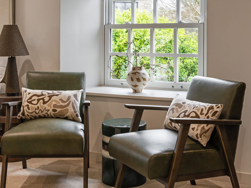A living room with two chairs and a vase on the windowsill at tbc in St. Ives