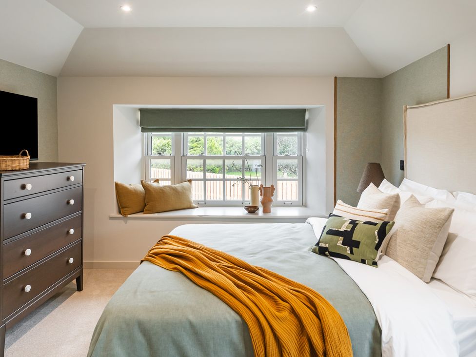 A bedroom with a bed and a dresser at tbc in St. Ives