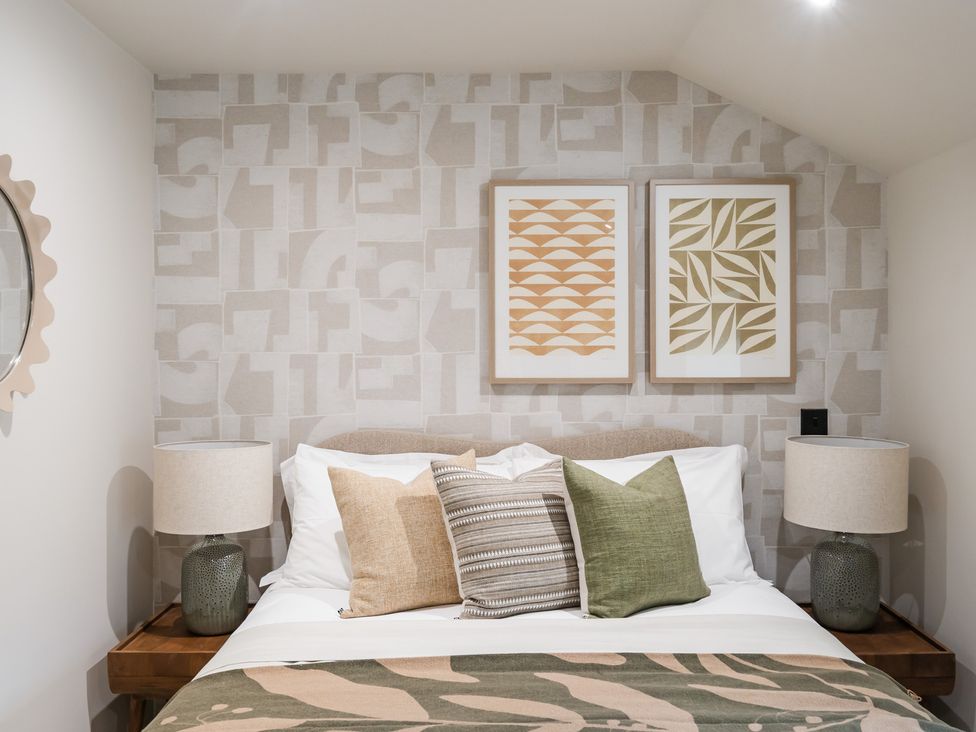 A bedroom with a bed and cushions at tbc in St. Ives