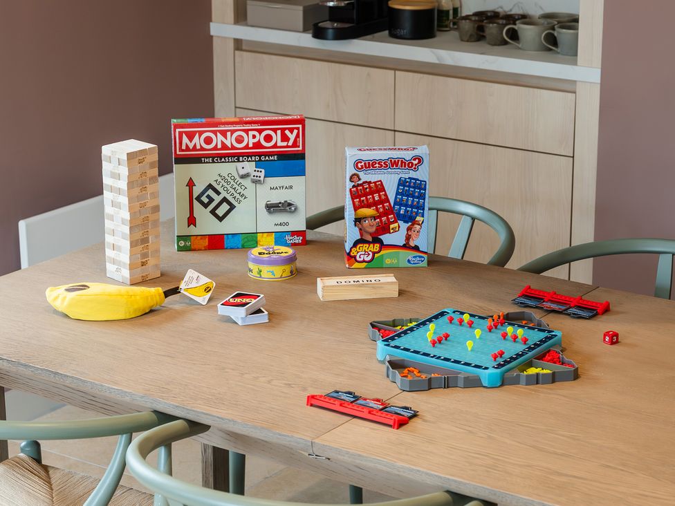 A dining room table with various board games at Hidden 7- Coastal Loft St Ives