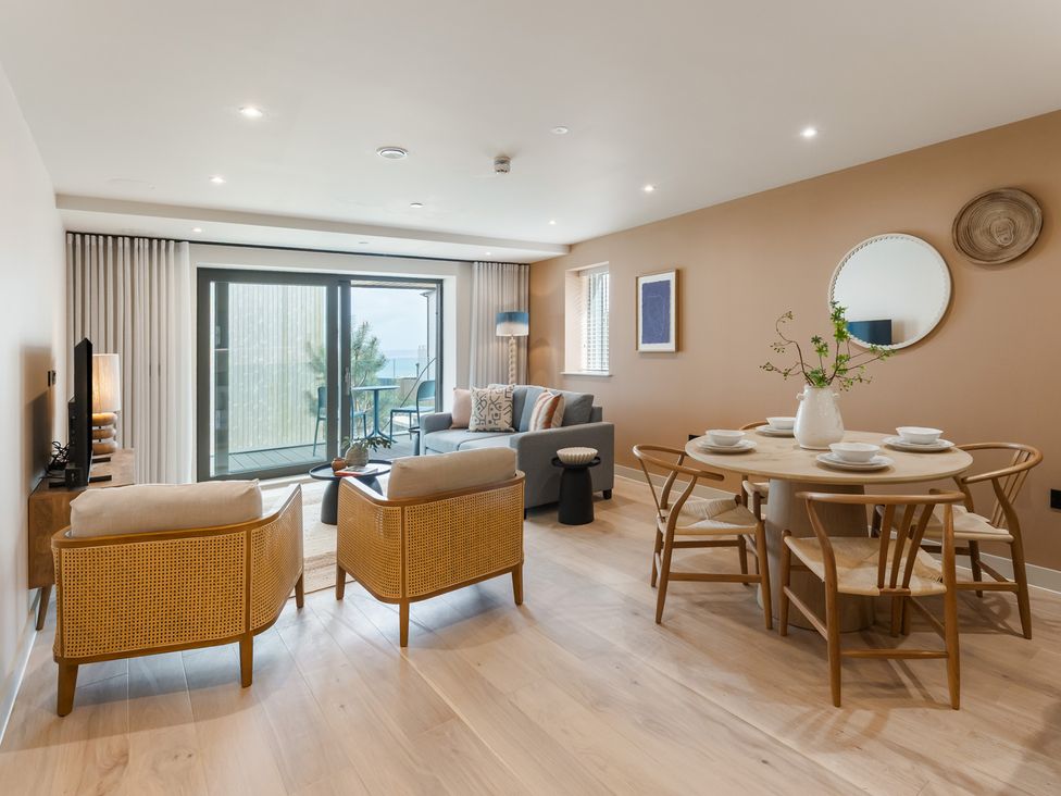 A living room with a sofa and dining table at The Old Barn in St. Ives