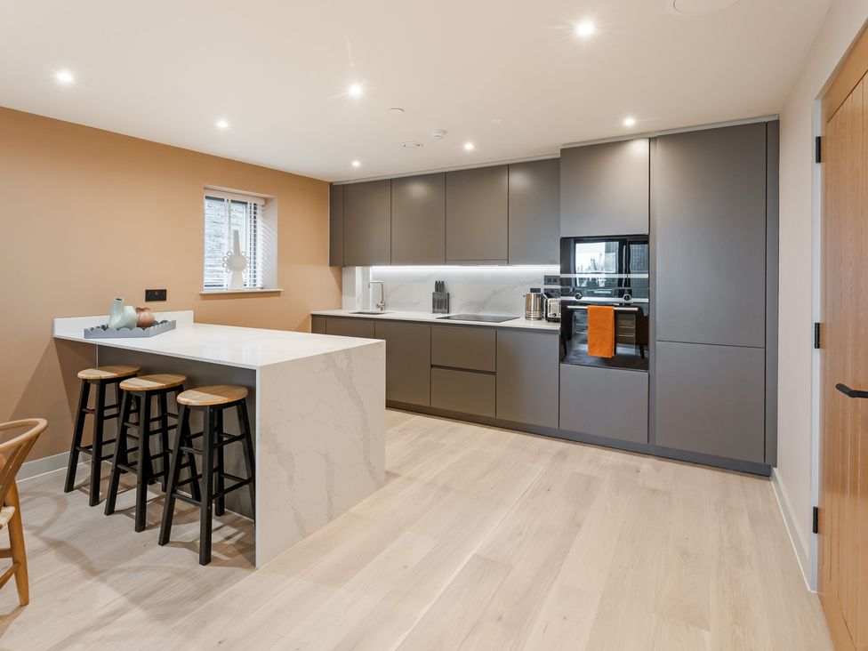 A kitchen with a countertop and stools at tbc in St. Ives