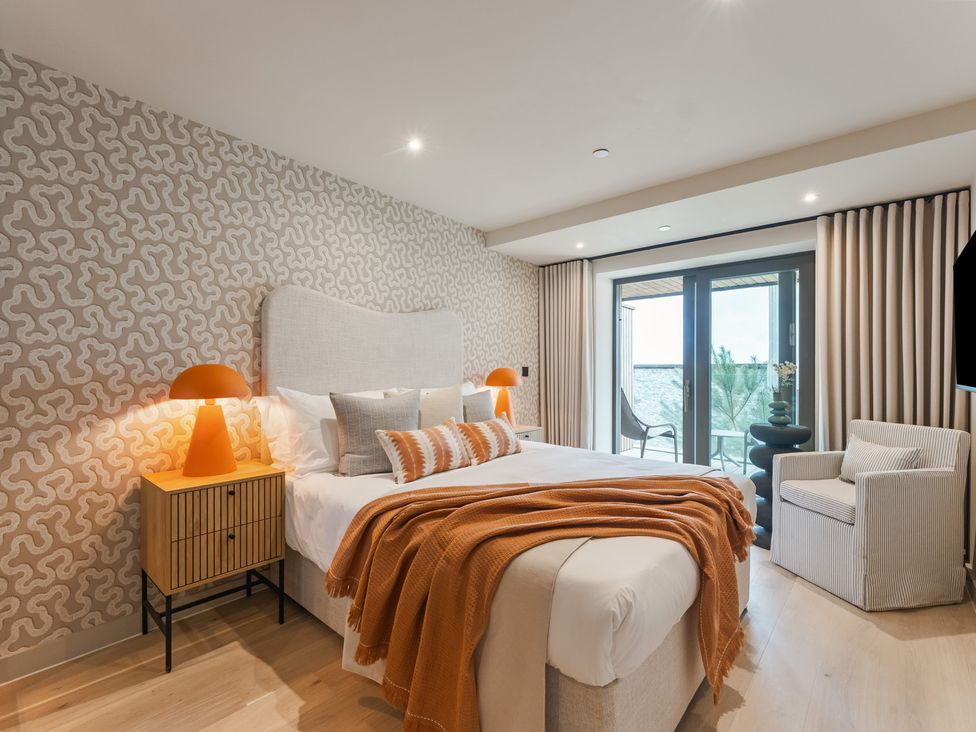 A bedroom with a bed and sliding door at tbc in St. Ives