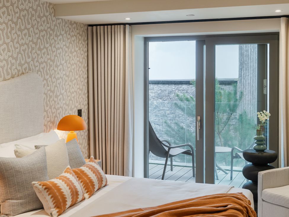 A bedroom with a bed and sliding door to balcony at tbc in St. Ives