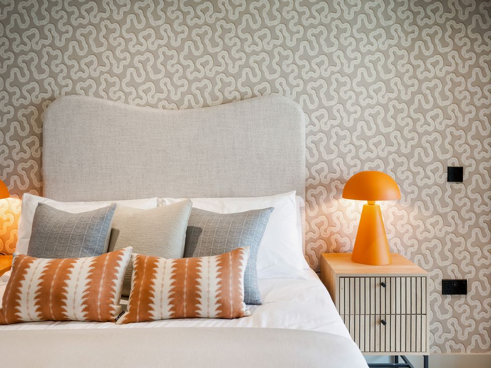 A bedroom with a bed and decorative pillows at tbc in St. Ives