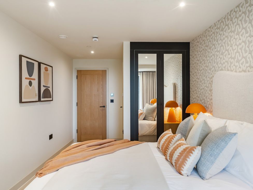 A bedroom with a bed and decorative art at tbc in St. Ives