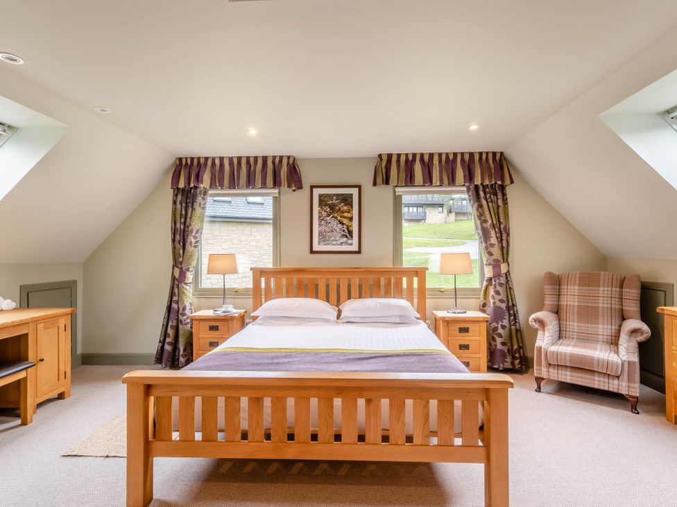 A bedroom with a bed and armchair at The Derwent Spa (Pet) Slaley