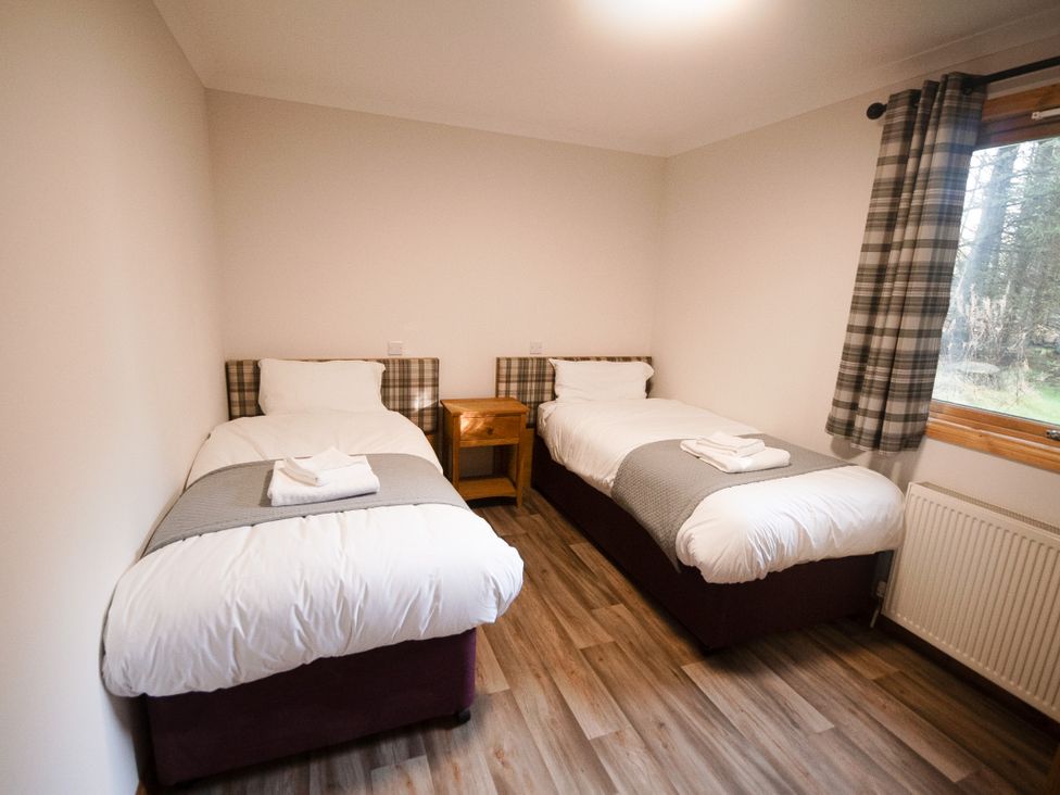 A bedroom with two single beds and a nightstand at Sidlaw Spa, Fowlis near Dundee