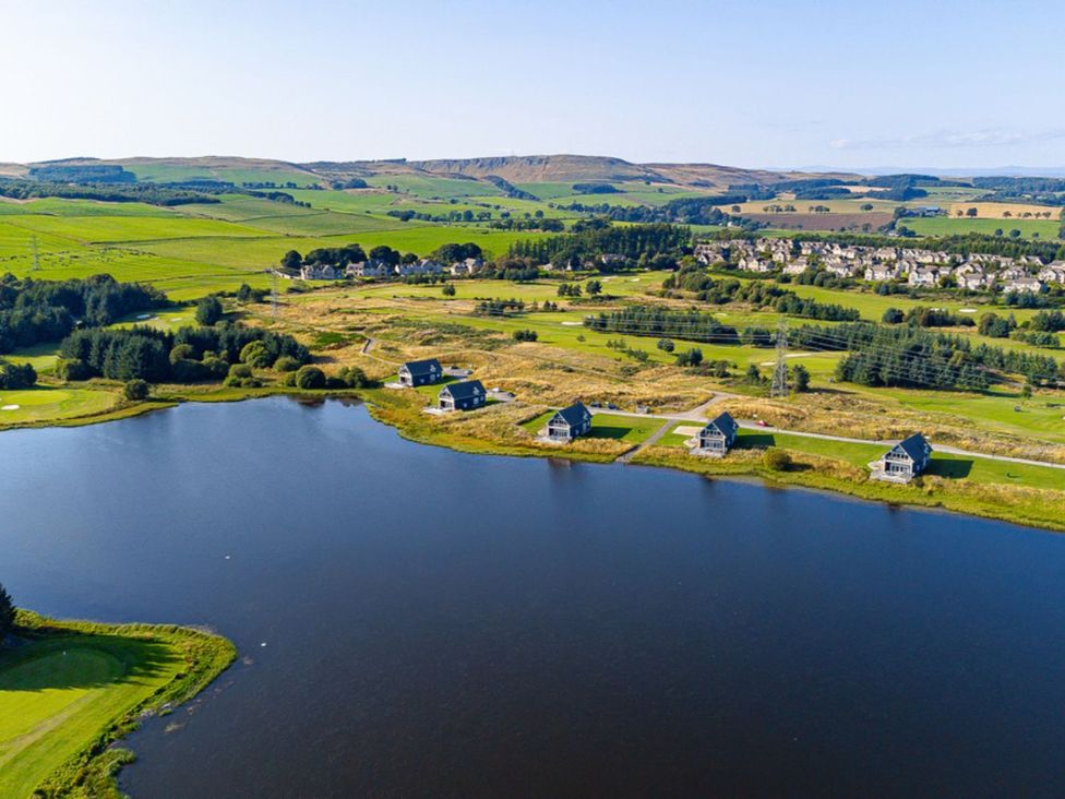An aerial view of houses near a lake at Sidlaw Spa (Pet) Fowlis near Dundee