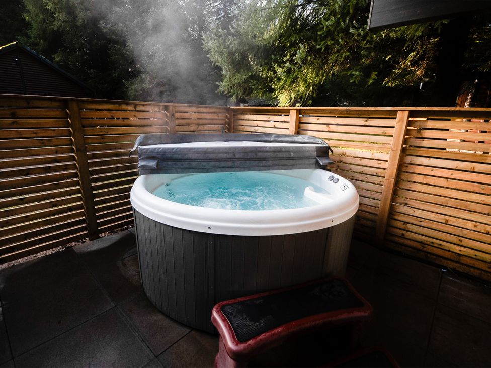 A hot tub with a cover in an outdoor area at Sidlaw Spa (Pet) Fowlis near Dundee
