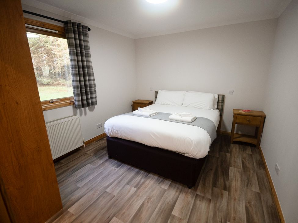 A bedroom with a bed and bedside tables at Sidlaw Spa (Pet) Fowlis near Dundee
