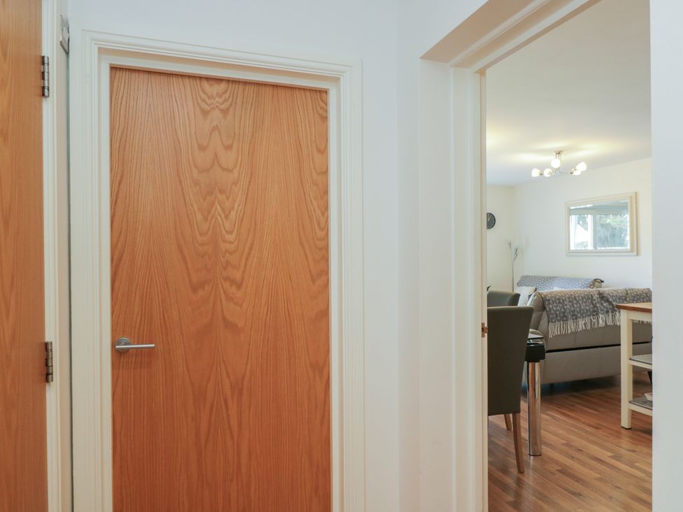 A view of a dining room with a wooden door at 7 Blue Water in Bournemouth