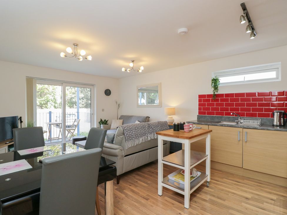 A living room with a sofa and dining table at 7 Blue Water Bournemouth