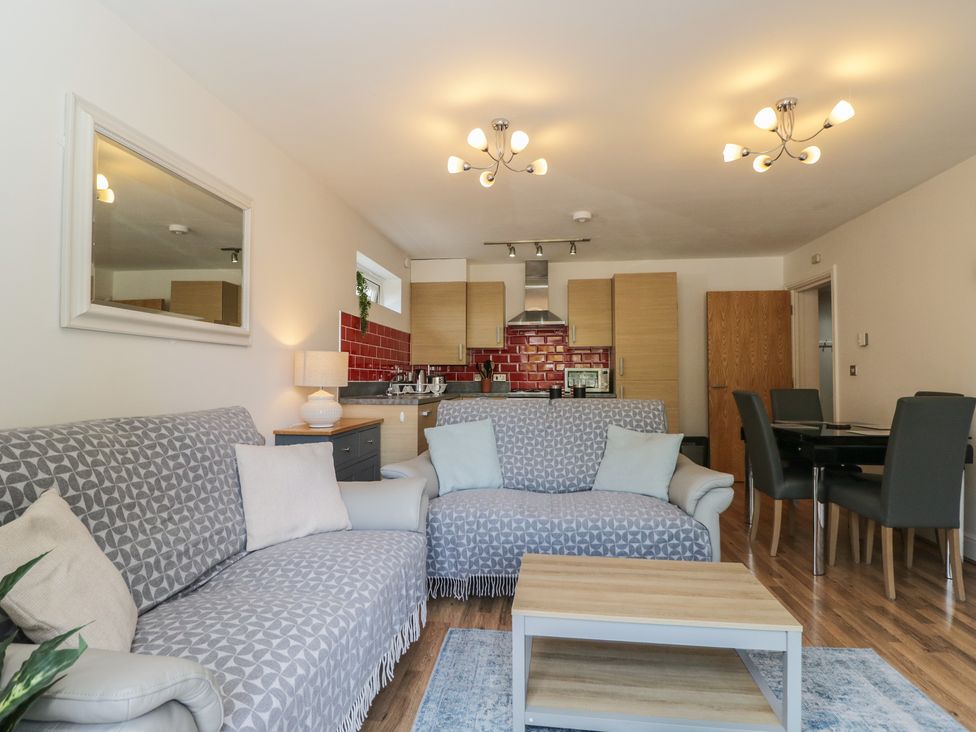 A living room with a sofa and dining area at 7 Blue Water in Bournemouth