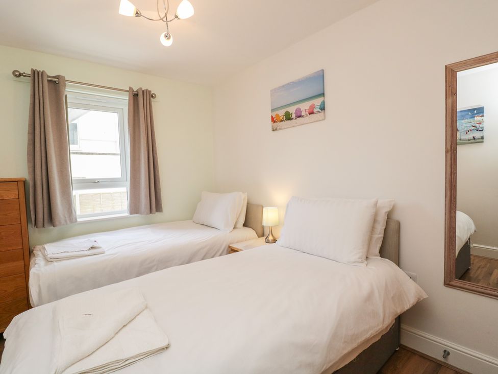 A bedroom with two single beds and a window at 7 Blue Water in Bournemouth