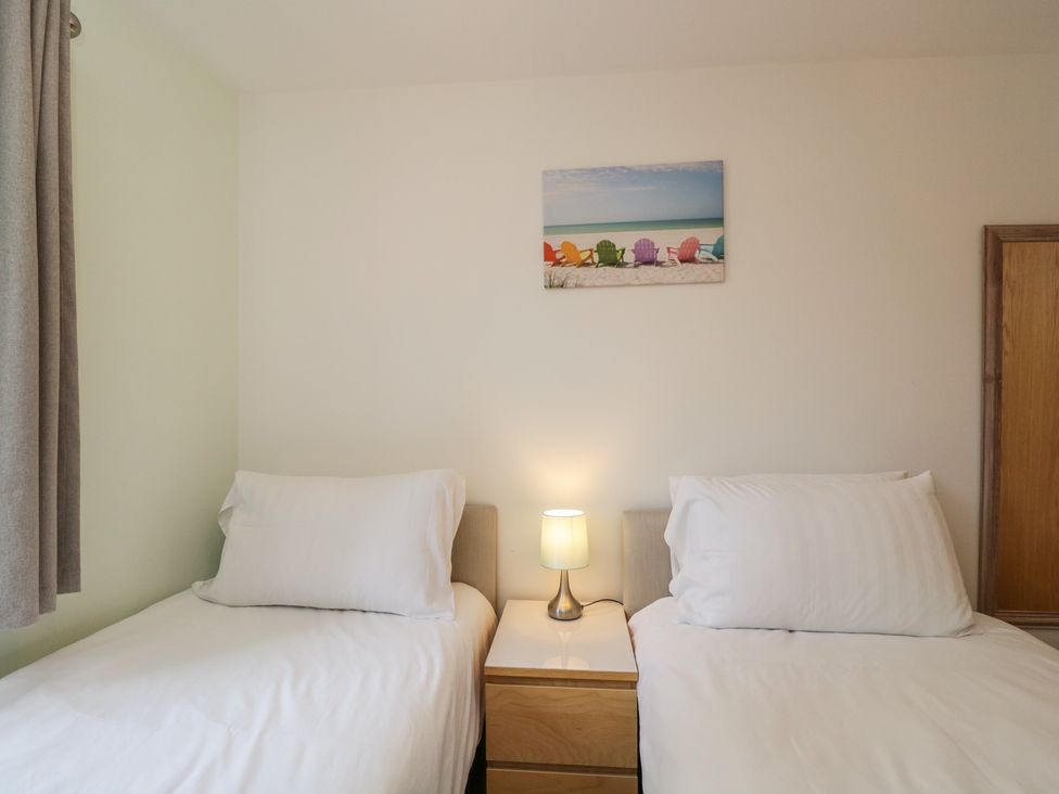 A bedroom with two beds and a lamp at 7 Blue Water in Bournemouth