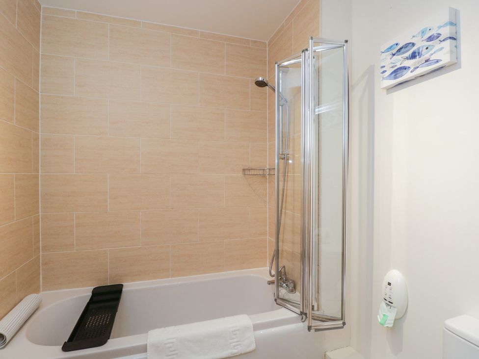 A bathroom with a bathtub and shower at 7 Blue Water in Bournemouth