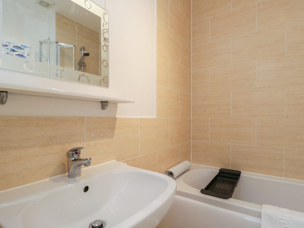 A bathroom with a sink and a bathtub at 7 Blue Water in Bournemouth