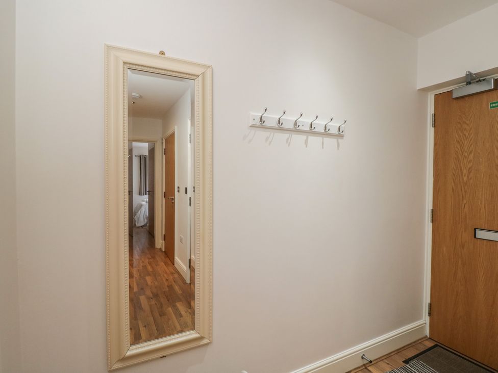 A hallway with a mirror and coat hooks at 7 Blue Water in Bournemouth