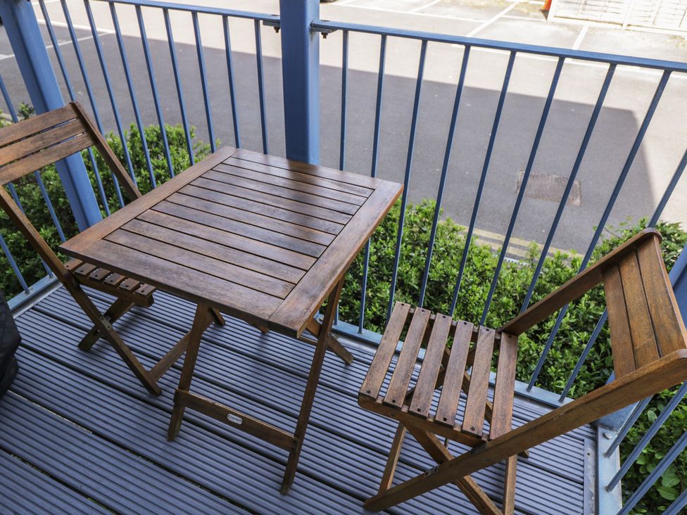 A table and chairs on a balcony at 7 Blue Water in Bournemouth
