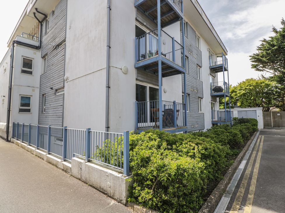 An outdoor view of a building with balconies and bushes at 7 Blue Water in Bournemouth