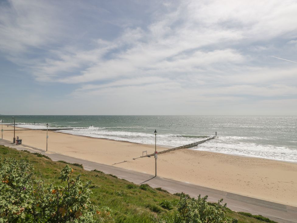 A beach with a pier and pathway at 7 Blue Water in Bournemouth