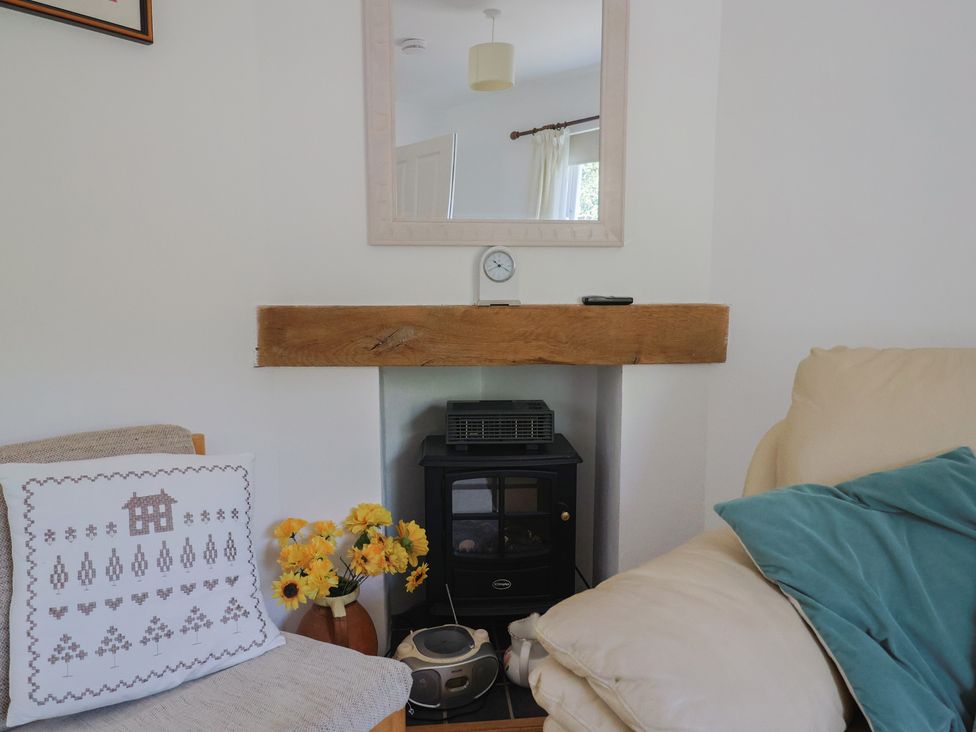 A living room with a stove and decorative items at Morpeth in Combe St Nicholas