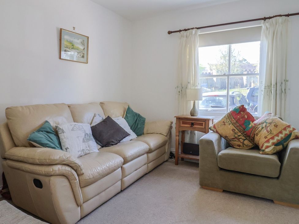 A living room with a leather sofa and armchair at Morpeth in Combe St Nicholas