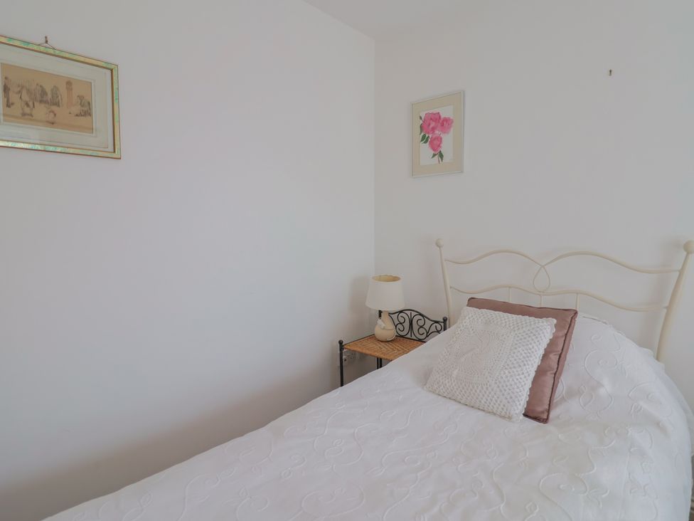A bedroom with a bed and a side table with a lamp at Morpeth in Combe St Nicholas