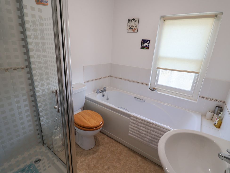A bathroom with a shower, bathtub, toilet, and sink at Morpeth in Combe St Nicholas