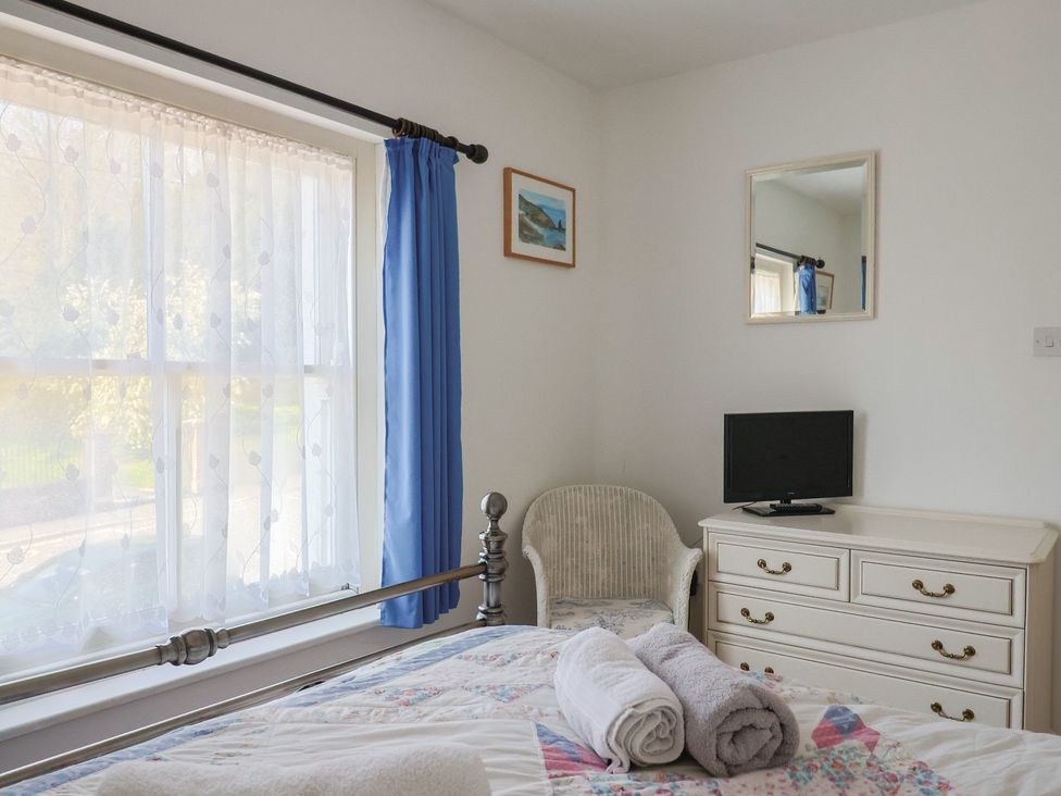 A bedroom with a bed, television, window and dresser at Morpeth in Combe St Nicholas