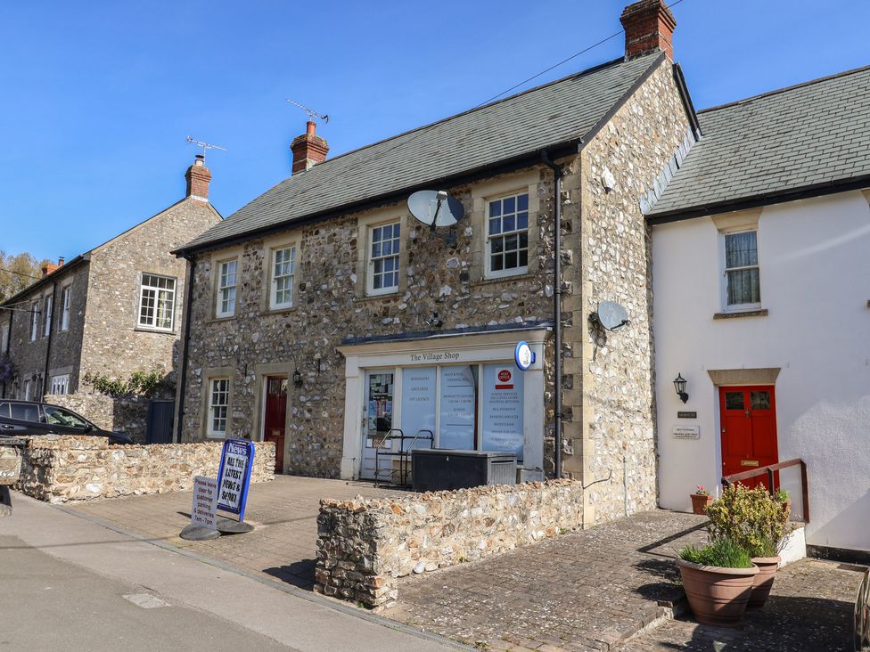 A shop front with stone building and windows at The Village Shop in Combe St Nicholas