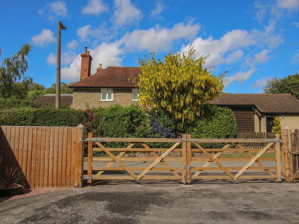 A house with a wooden gate and trees at Onny Views in Craven Arms