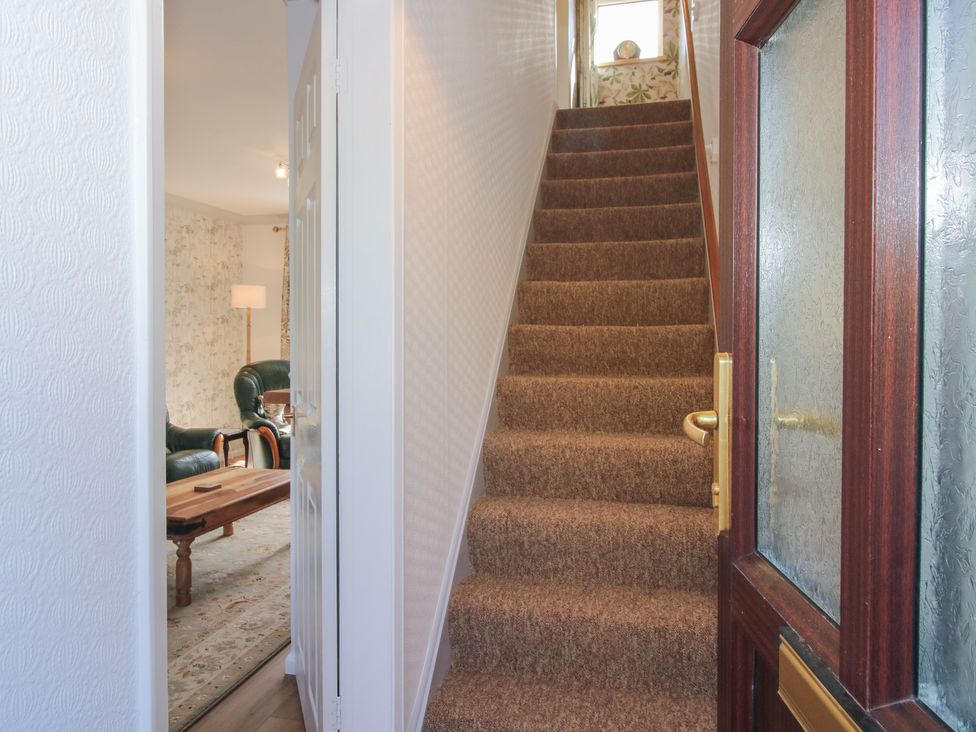 A hallway with a staircase and door at Onny Views in Craven Arms