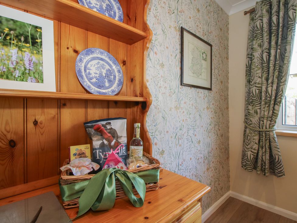 A kitchen with shelves containing plates and a basket at Onny Views in Craven Arms