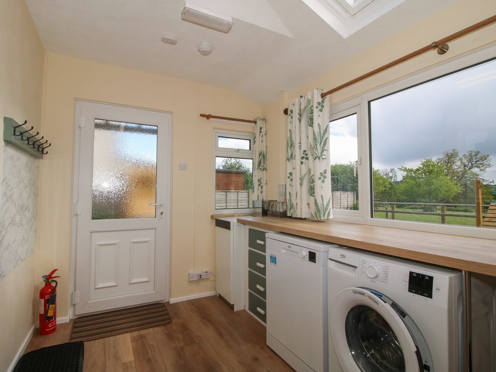 A utility room with a washing machine and countertop at Onny Views in Craven Arms