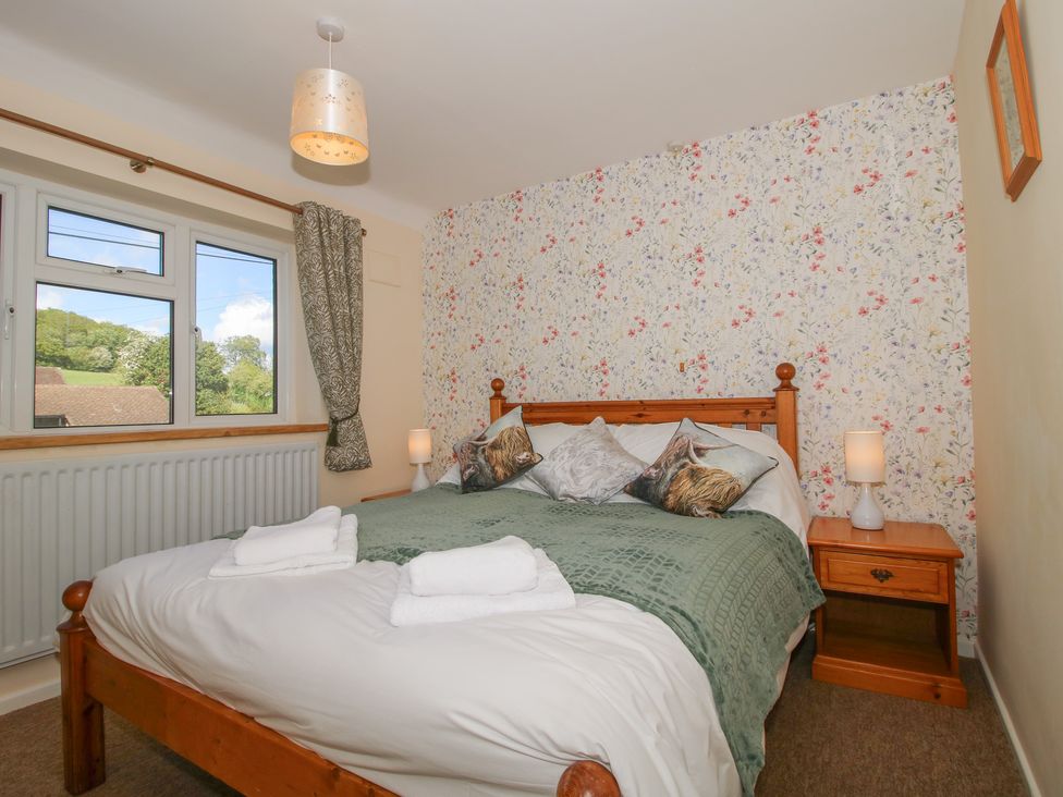 A bedroom with a bed and bedside table at Onny Views in Craven Arms