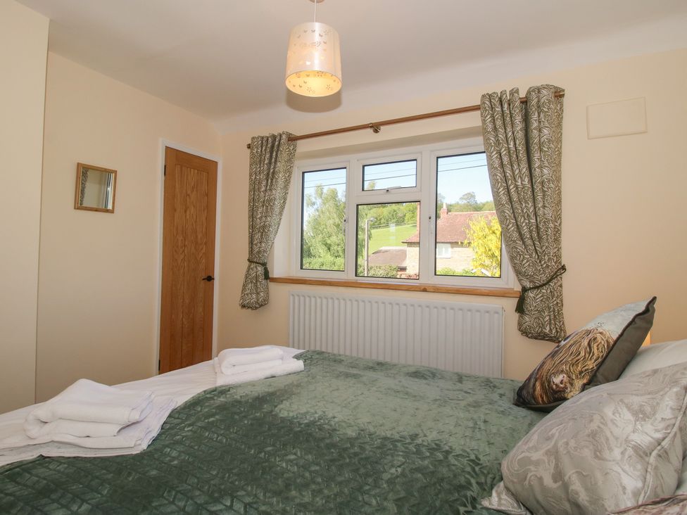 A bedroom with a bed and window at Onny Views in Craven Arms