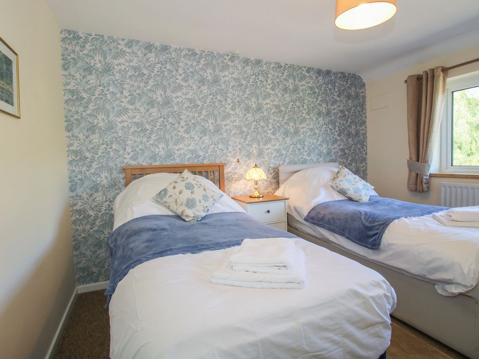 A bedroom with two single beds and a nightstand at Onny Views in Craven Arms