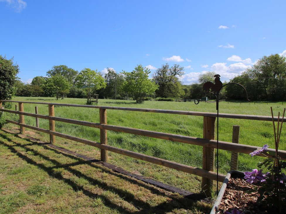 An outdoor area with a fence and grass at Onny Views in Craven Arms