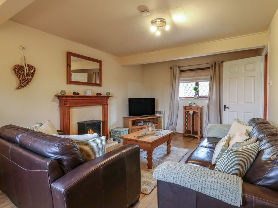 A living room with sofa and coffee table at Barclay Cottage in Biddenden